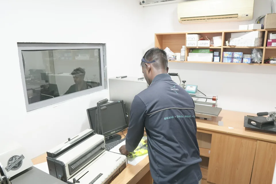 Victory technician at the sublimation and finishing bench with heat-press machines