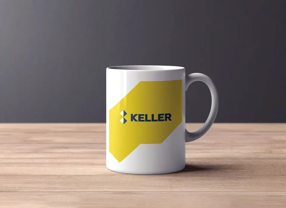 White mug branded with the yellow Keller logo